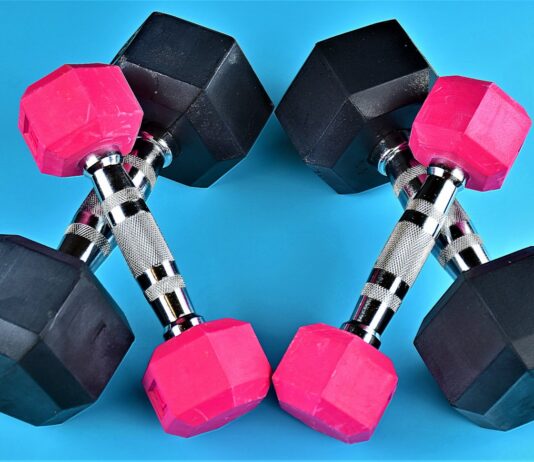 장기적인 건강관리를 위한 운동전략 a pair of pink and black dumbs on a blue background