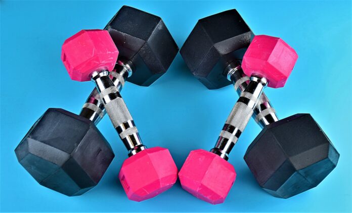 Photo by Ray Shrewsberry a pair of pink and black dumbs on a blue background