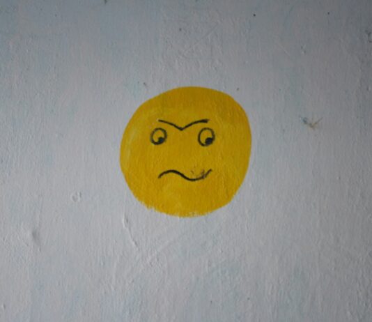 감정 에너지 관리법: ‘정서 배터리’ 회복 루틴 a yellow smiley face painted on a white wall