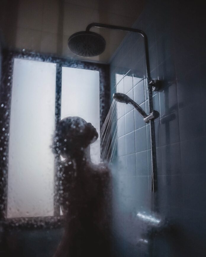 Photo by Hannah Xu woman under showerhead