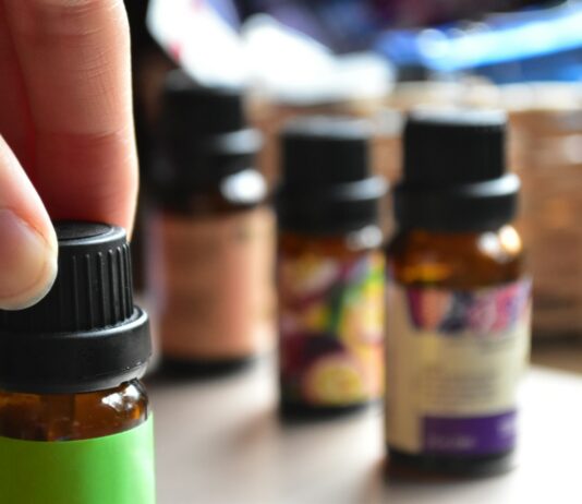 일상 속에 스며드는 대체요법, 간편하게 즐기는 건강 습관 a hand touching a bottle of essential oils