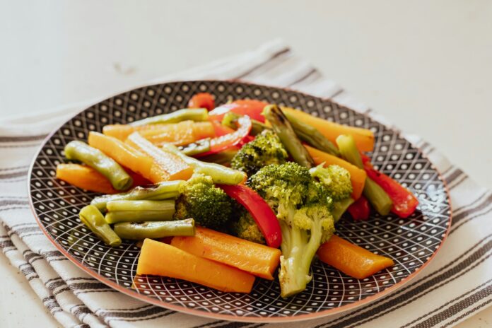 Photo by The Design Lady a plate of broccoli, carrots, and peppers