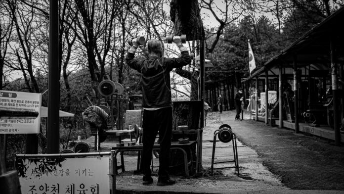 man in black jacket and pants standing on a ladder