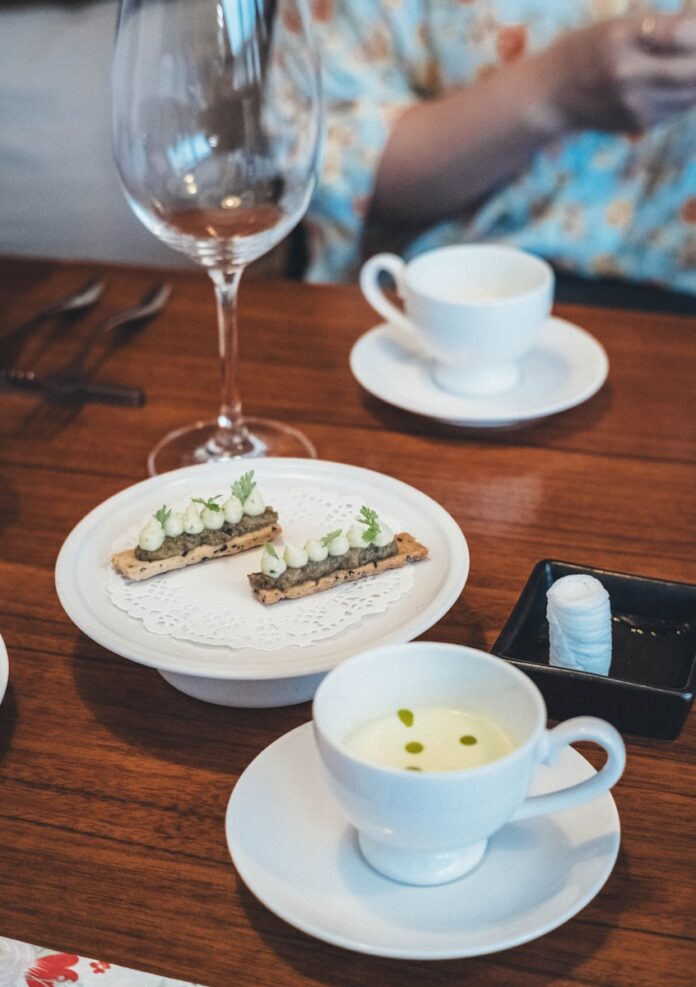 Photo by Bundo Kim Gourmet appetizers and soup served on a wooden table.