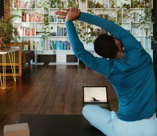 집에서도 간편하게, 건강 챙기는 ‘마이크로 운동’ 열풍 a man doing yoga in a living room